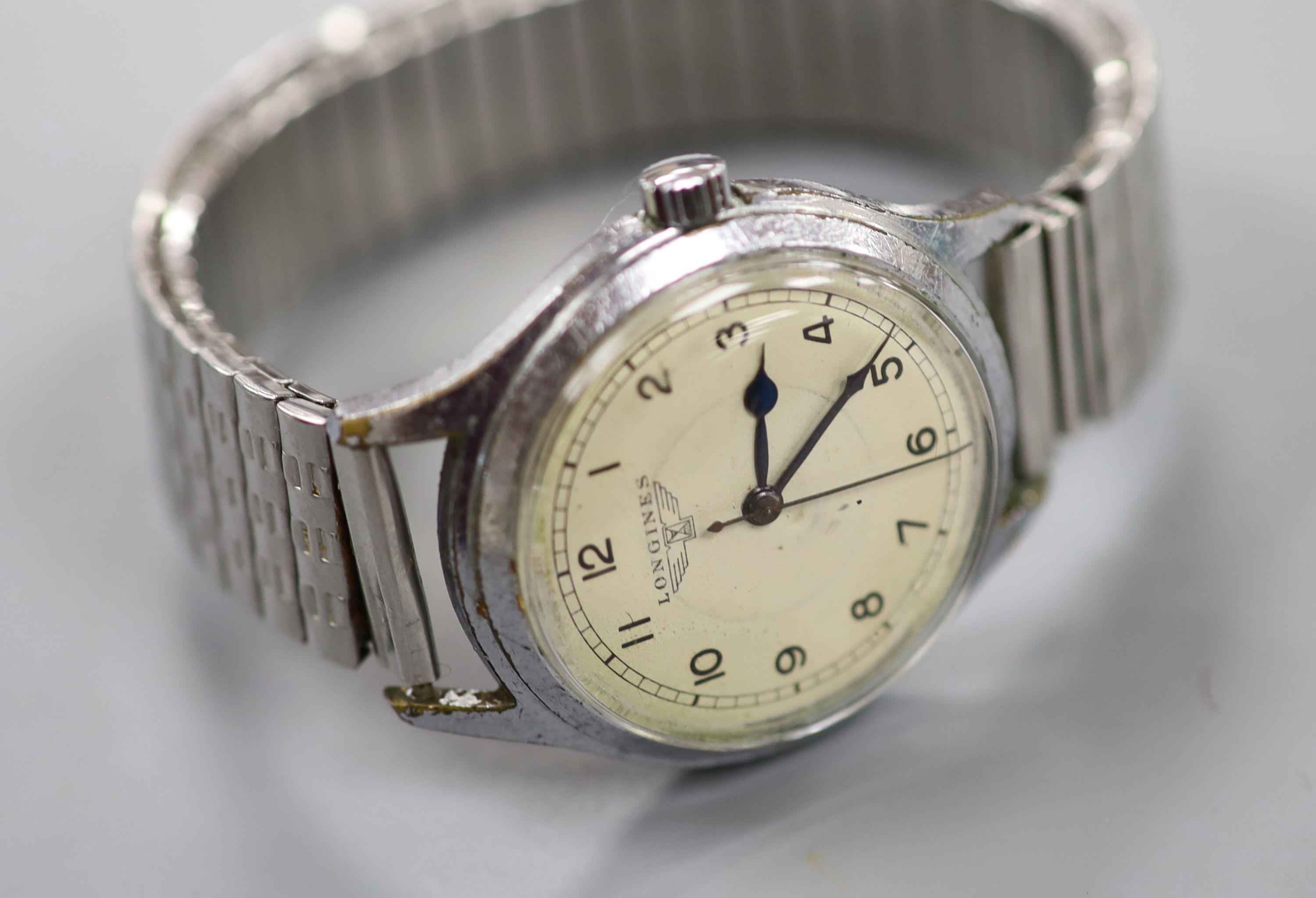 A gentleman's mid 20th century stainless steel Longines manual wind wrist watch, on associated flexible strap, case diameter 34mm.